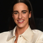 Caitlin Clark net worth featured image showing the basketball superstar smiling during a public appearance, highlighting her growing wealth, endorsements, and career success.