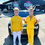 Island Boys net worth showcased by the viral twins standing in matching yellow tracksuits in front of a luxury Rolls-Royce, highlighting their social media fame and wealth.
